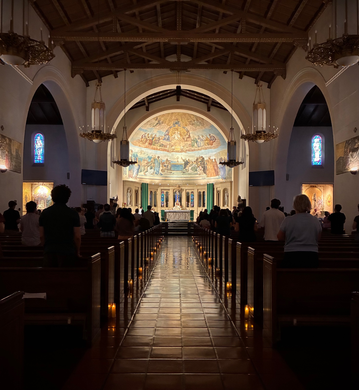 The Sunday candlelight Mass at St. Philip the Apostle, Pasadena: a full church standing, candles along the aisle